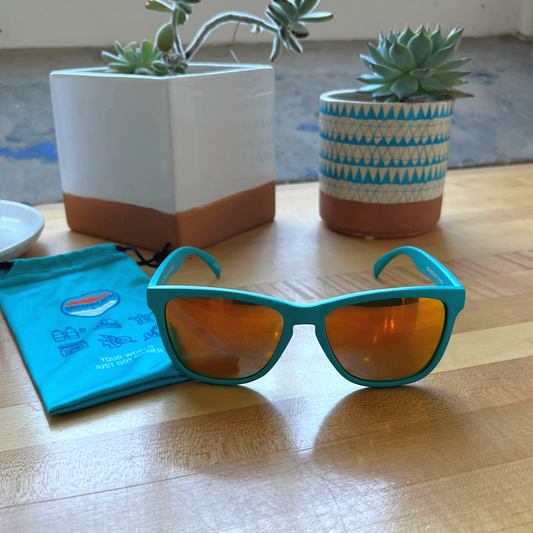 sunglasses with light teal frames and orange polarized lenses with Broadreach on stem